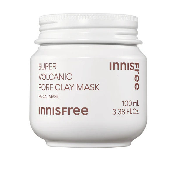 Jar of Innisfree Super Volcanic Pore Clay Mask 2X with smooth gray clay texture, sitting next to natural volcanic rocks and leaves.