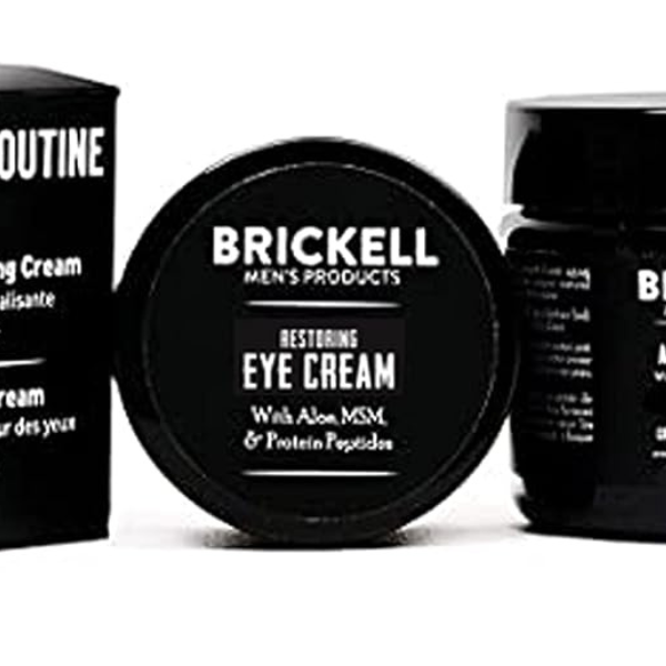 Brickell Men’s Restoring Eye Cream jar on a black marble counter with clean grooming essentials